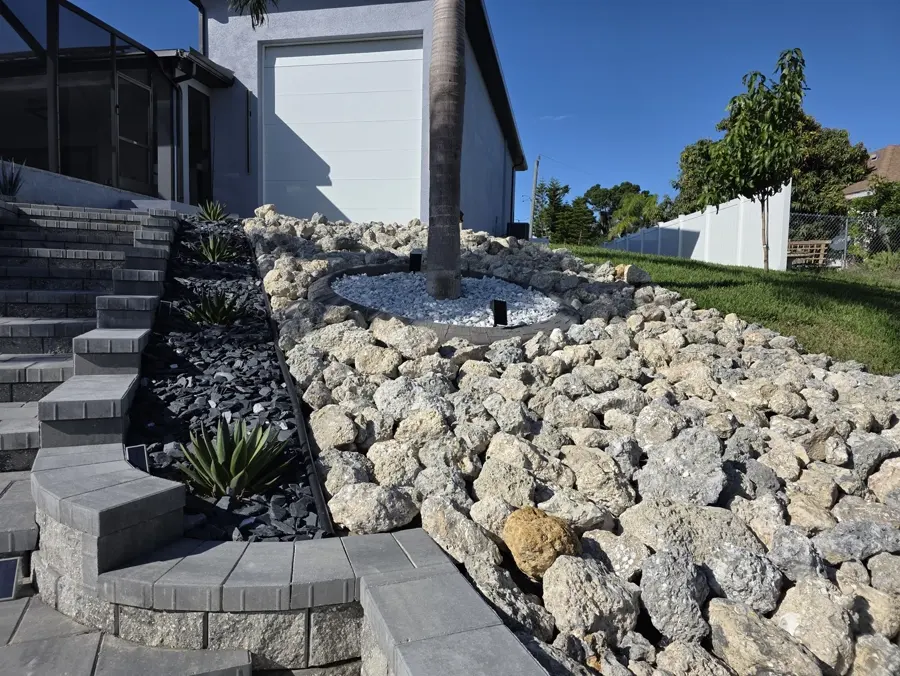 Large rock waterfront garden with paver steps and plantings