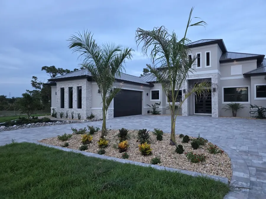 Paver driveway with island planting and palms at a luxury Southwest Florida home