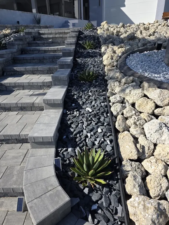 Tiered paver retaining wall with black rock, boulders and agave