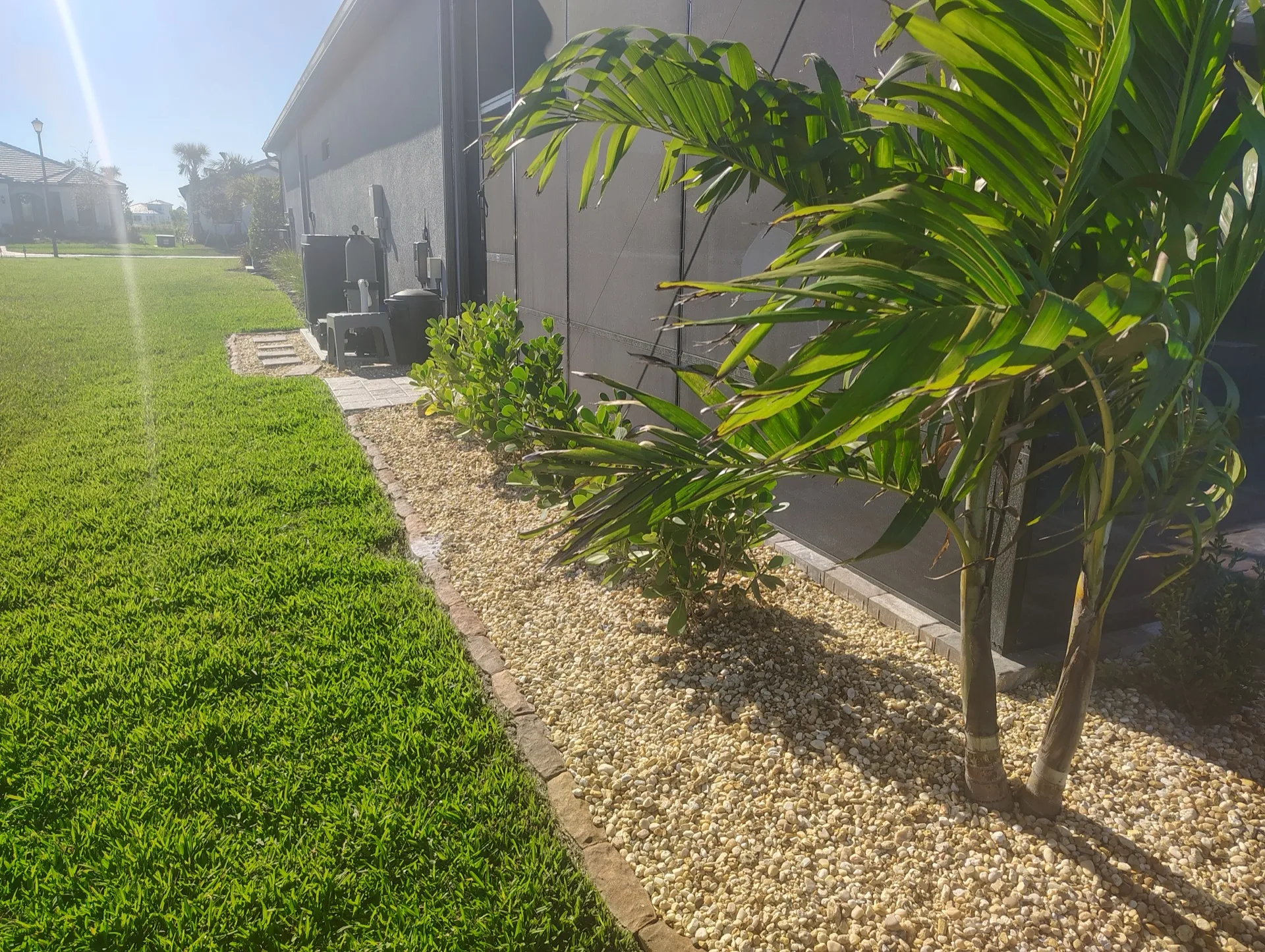 Concrete curbing with gold gravel rock beds at a Rotonda West lanai