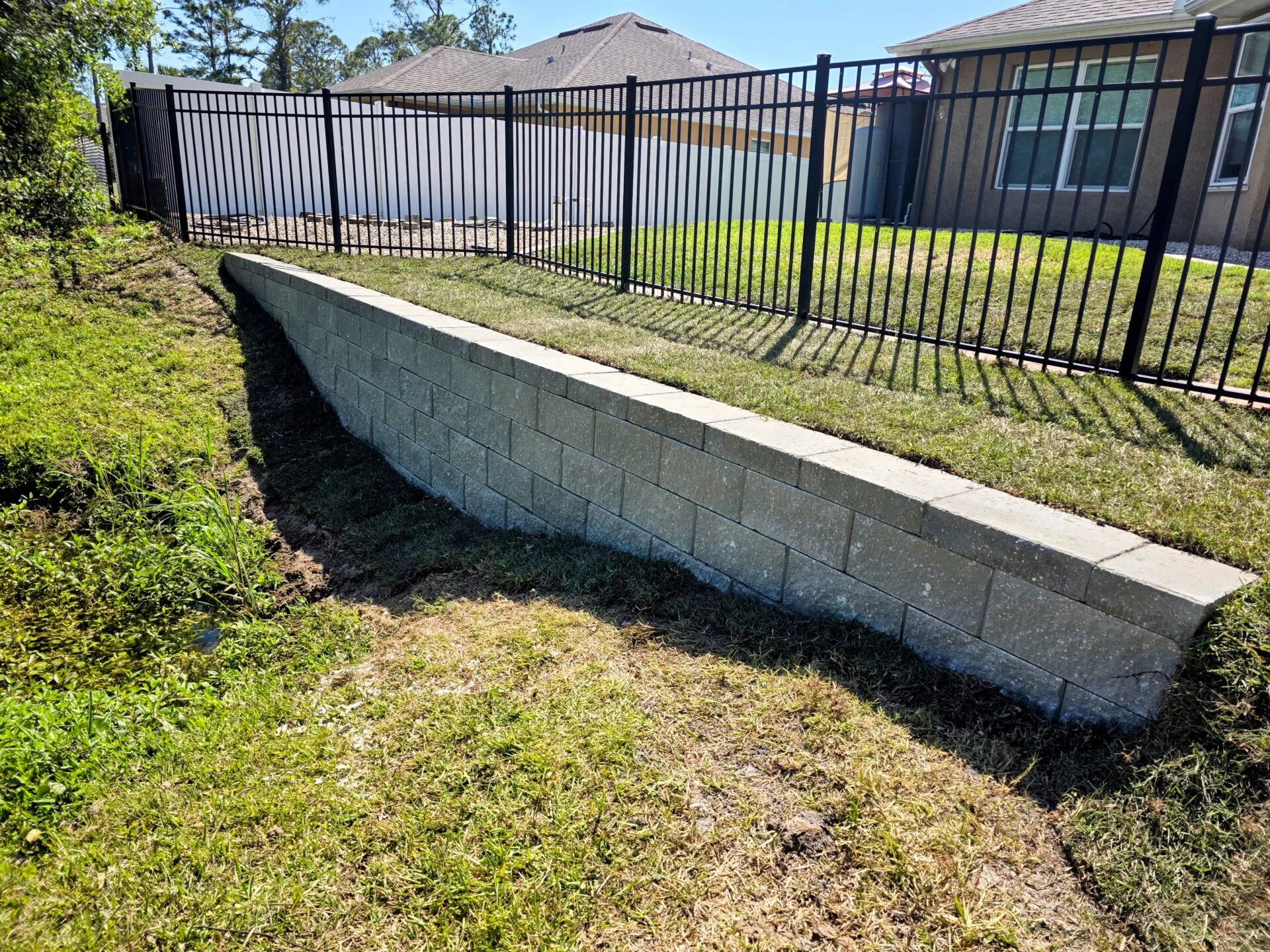 Block retaining wall installed in North Port FL — clean finish, erosion stopped