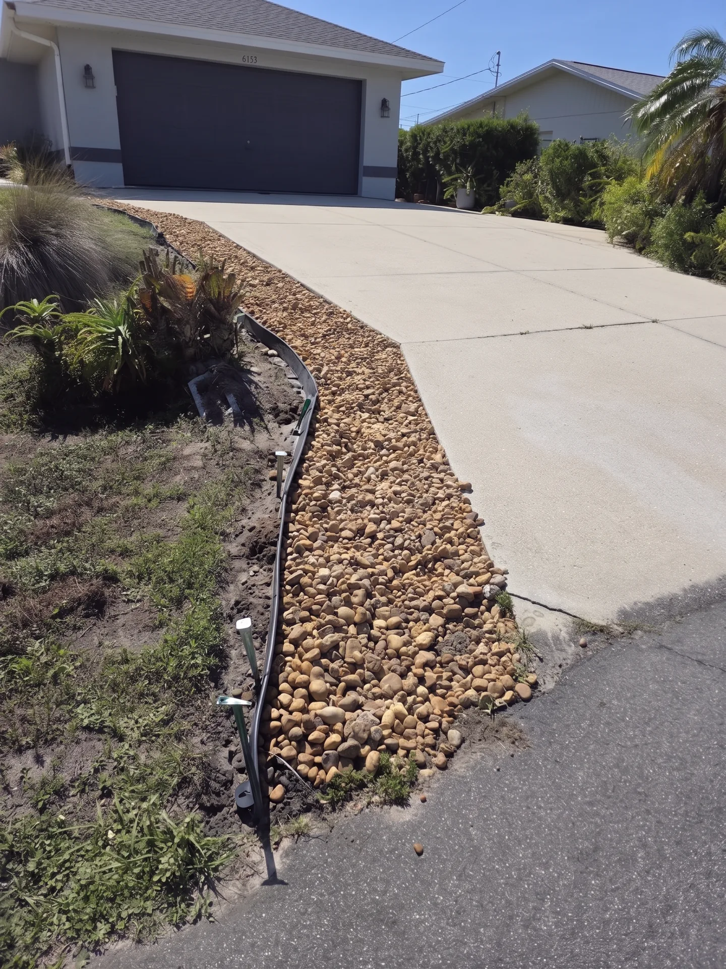 Overgrown landscaping before cleanup and concrete curbing installation