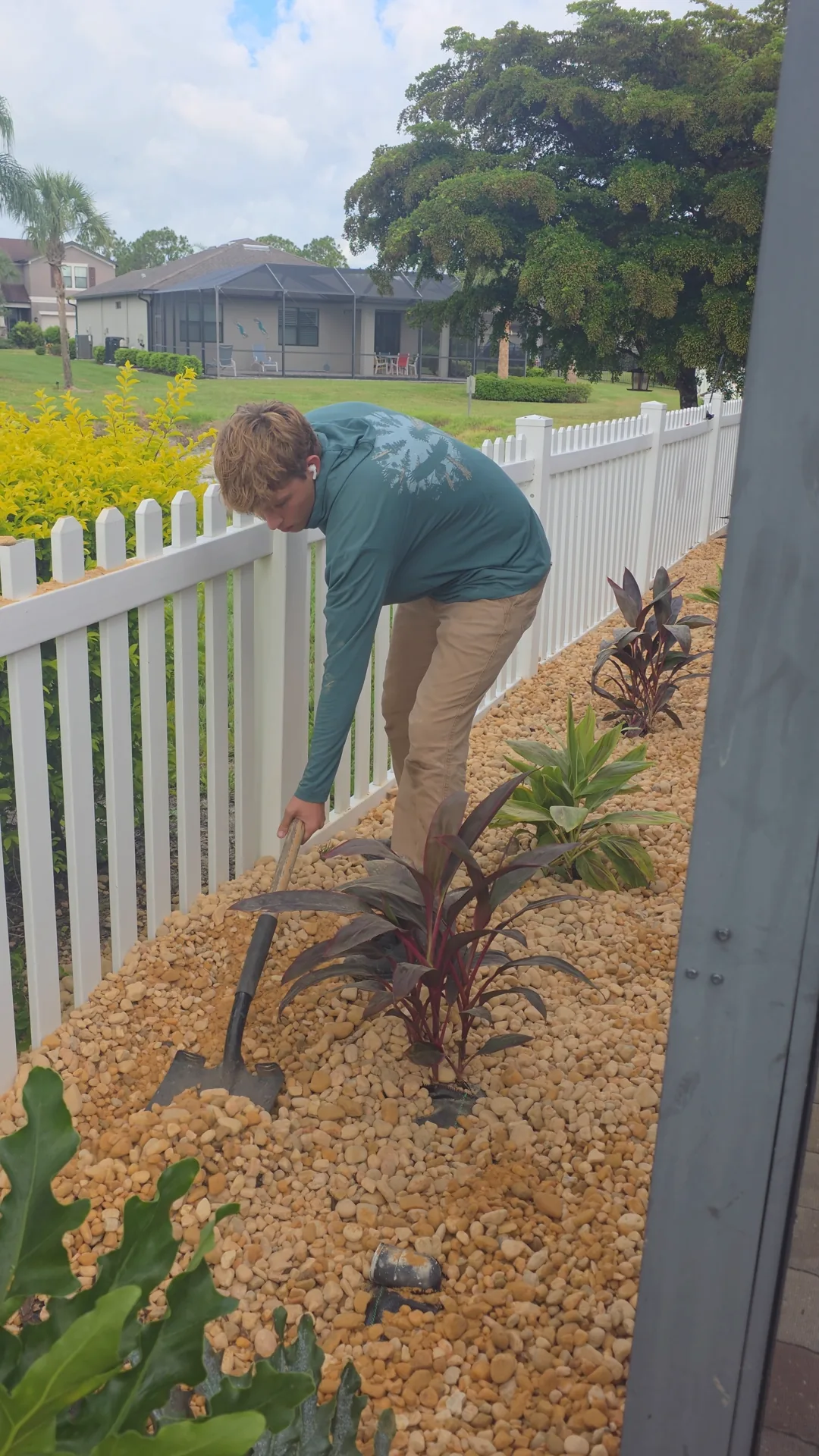 Epic Horizons crew member at a plant installation job with potted plants staged for planting