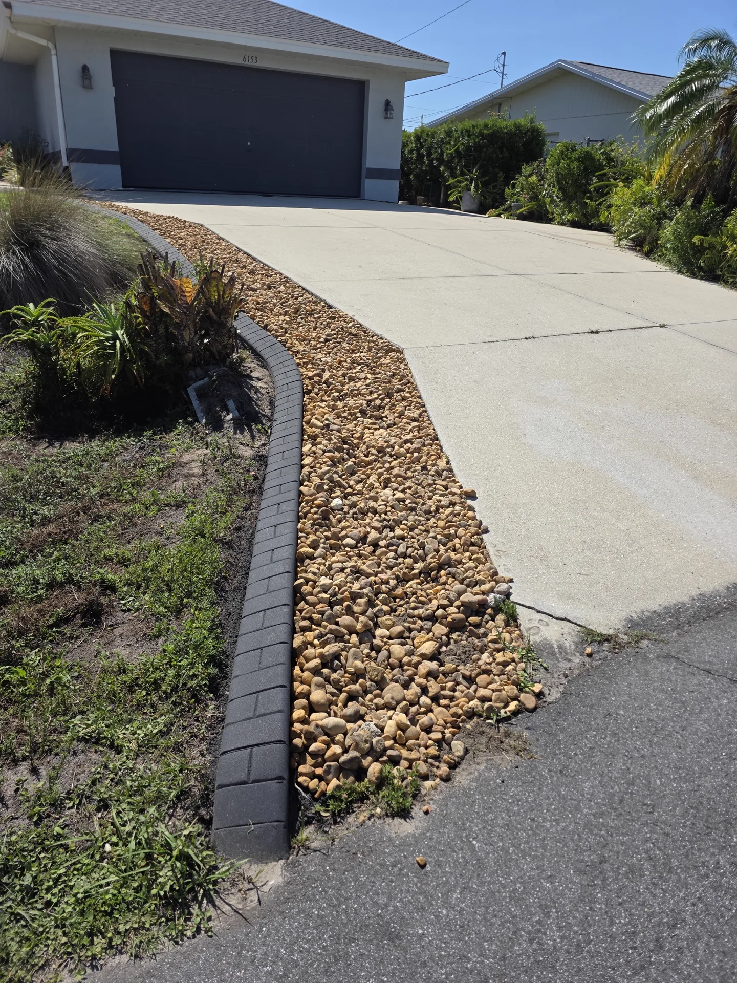 Finished landscaping with clean concrete curbing borders and fresh mulch beds
