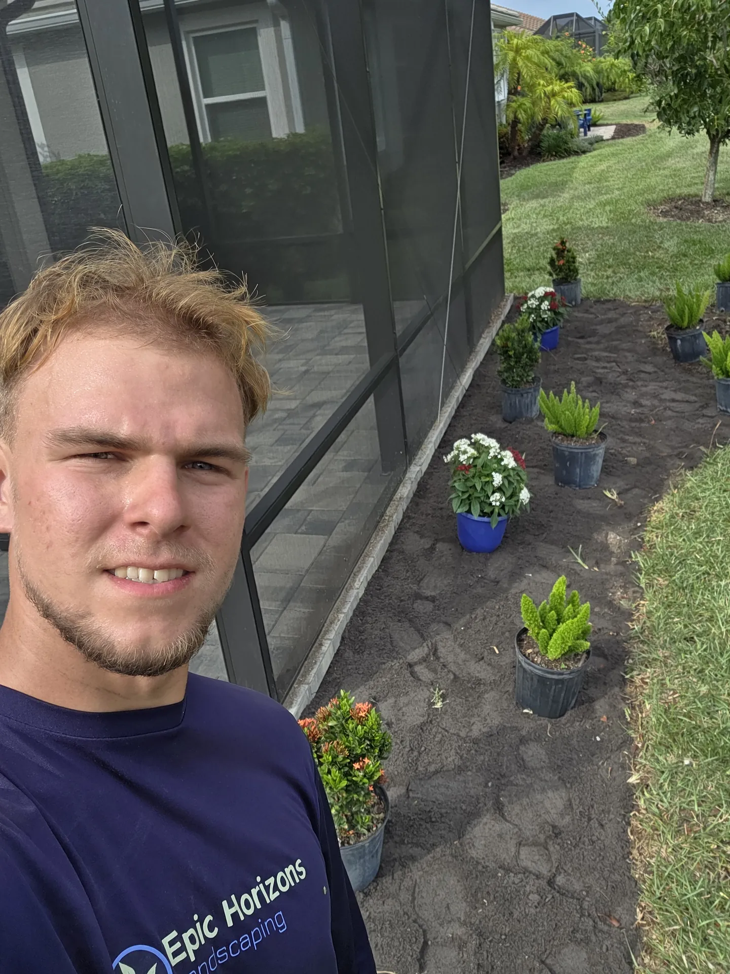 Epic Horizons crew member staging tropical plants for a full bed redesign