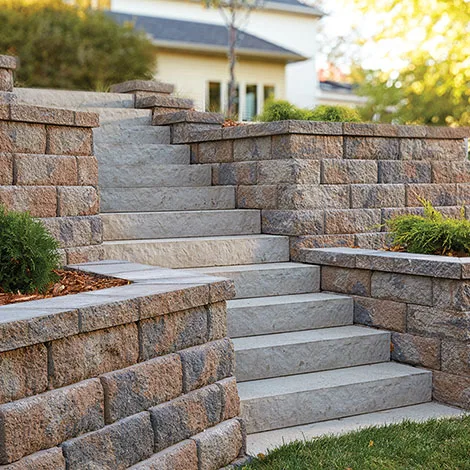 Terraced stone block retaining wall and staircase with planted beds
