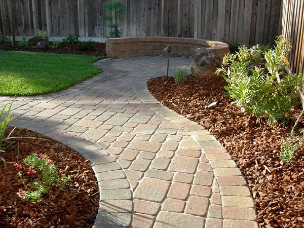 Worker hand-installing pavers during hardscaping
