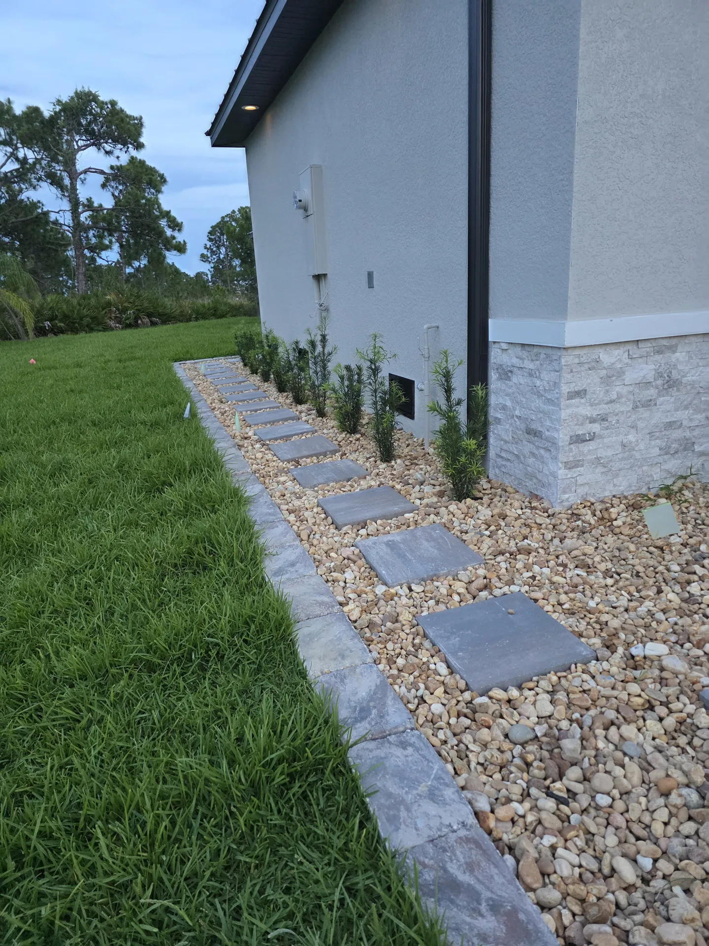 Paver stepping-stone path through a finished rock bed with a clean border