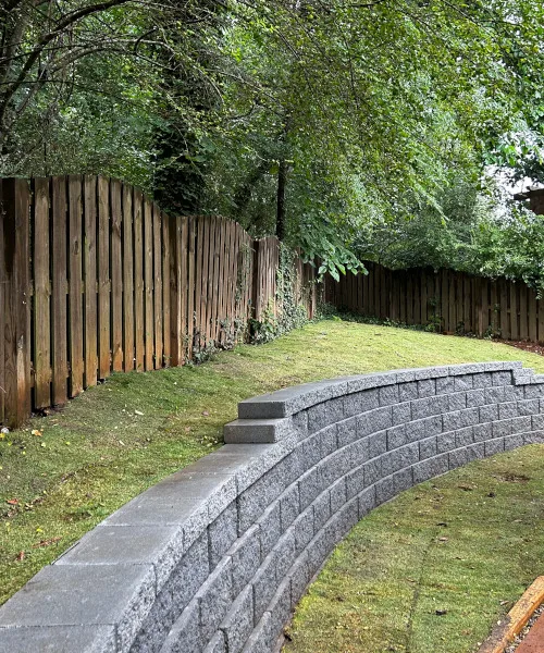 Heavy duty retaining wall in North Port FL backyard preventing fence collapse from soil erosion