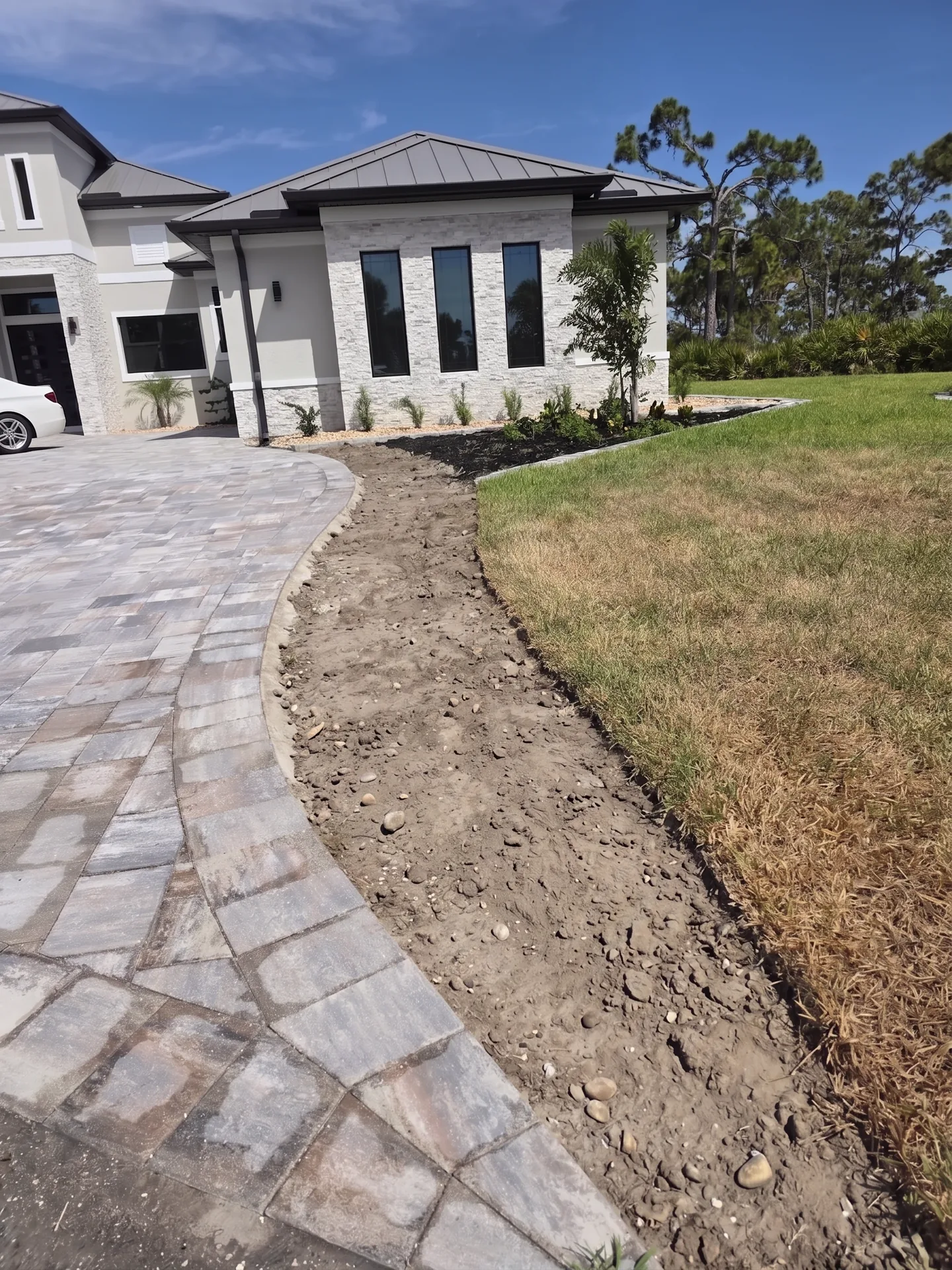 Bare, weedy landscape beds before rock installation