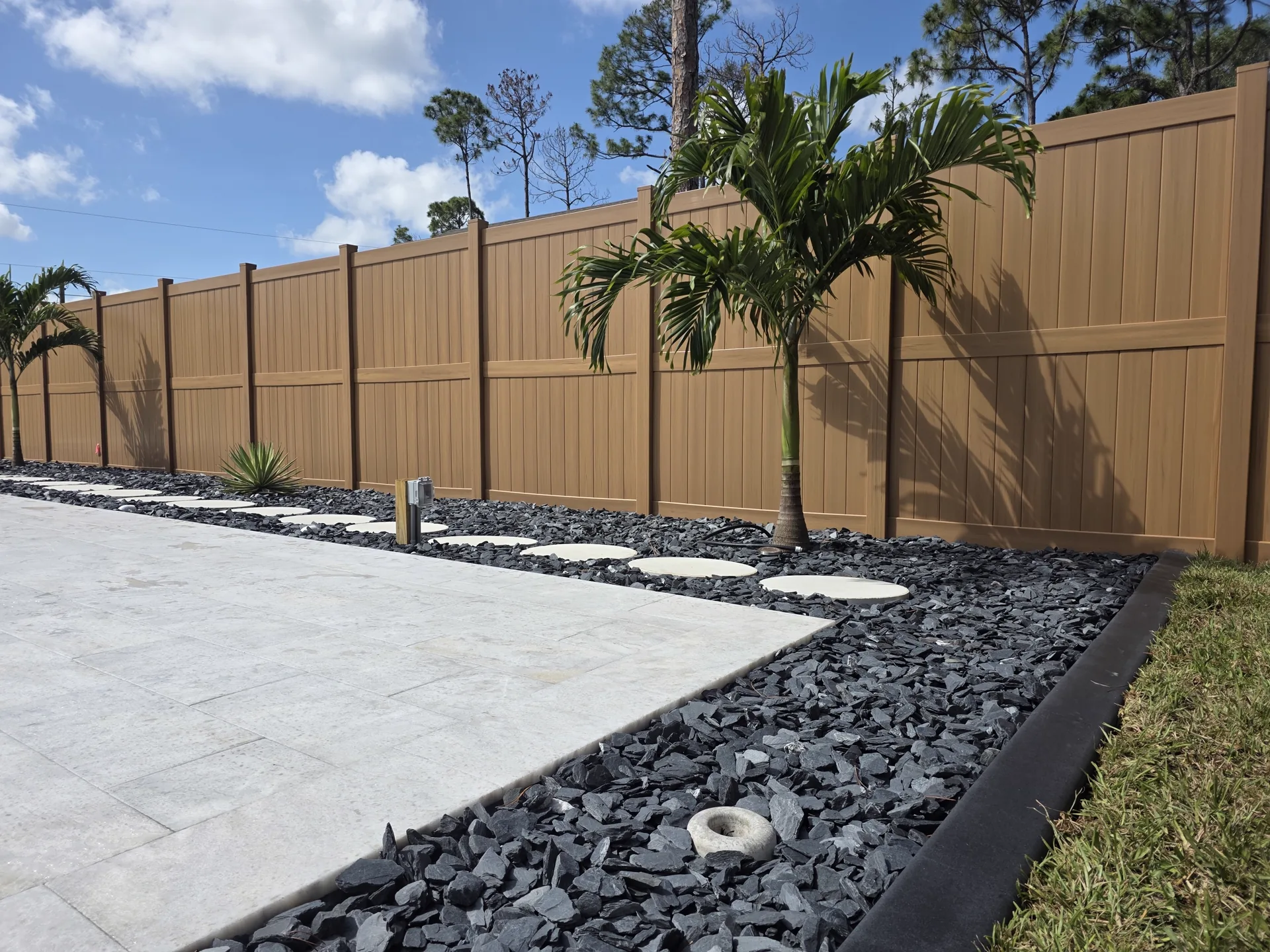 Renovated bed with podocarpus, rock mulch, and concrete curbing — Port Charlotte FL