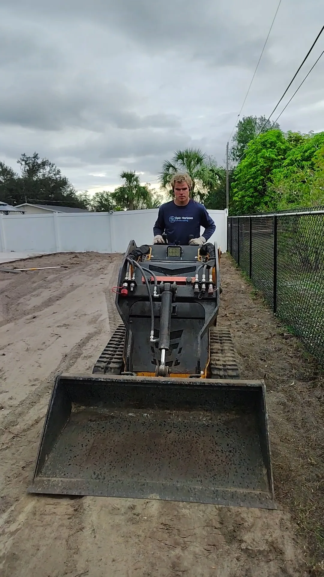 Skid steer operator assessing lot before clearing