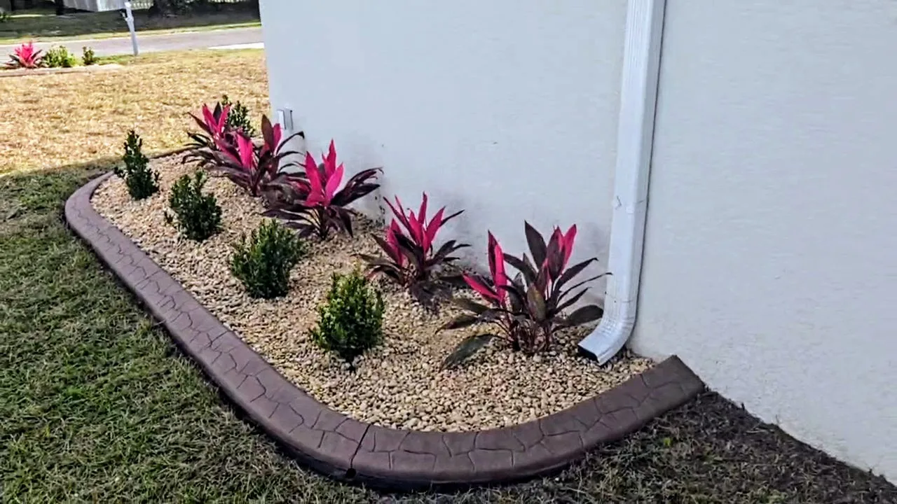 Concrete curbing with red ti plants and white rock bed — North Port FL